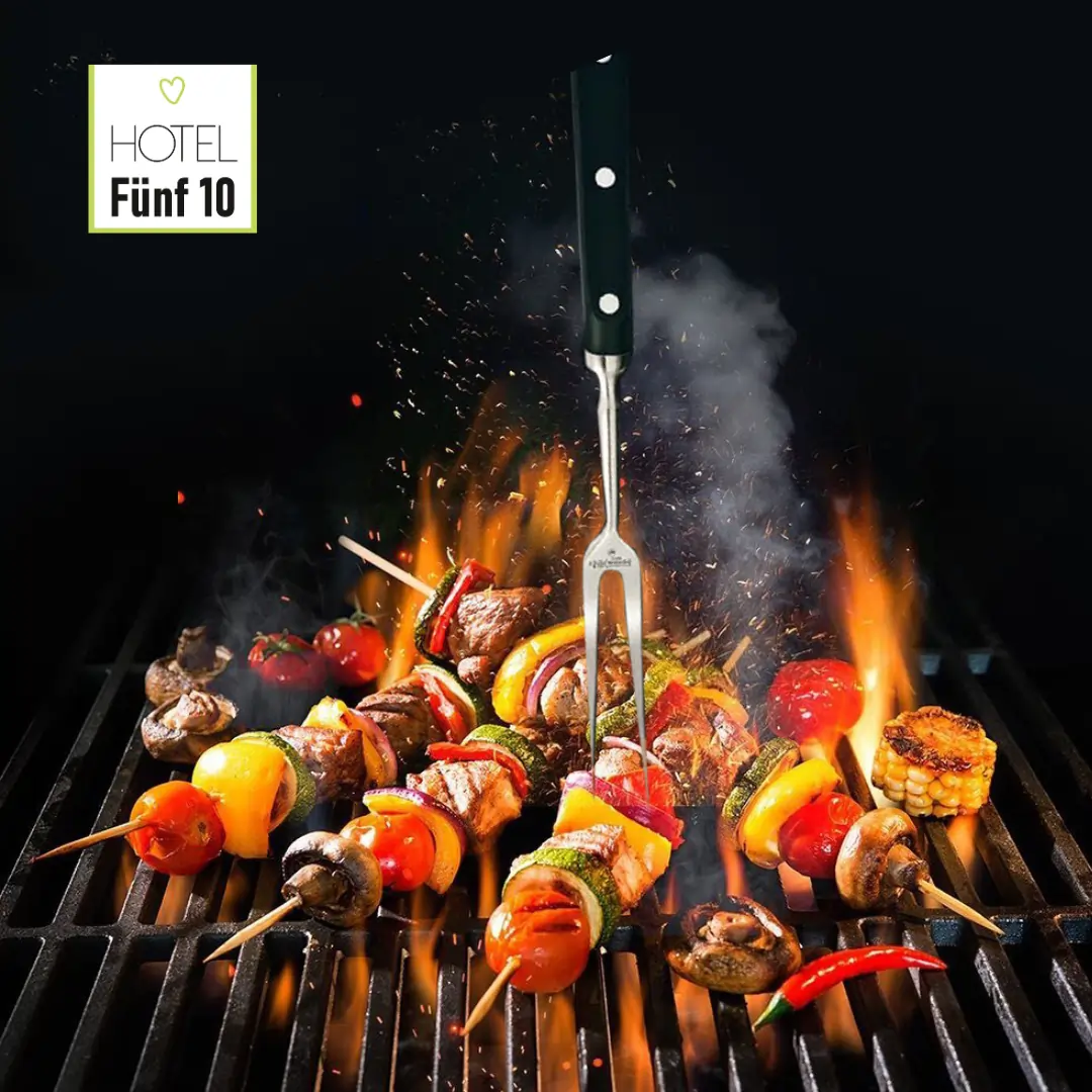 BBQ Sommer. Auf dem Bild sind bunte Grillspieße mit Gemüse und Fleisch zu sehen, die auf einem glühenden Grill brutzeln. Flammen züngeln auf und erzeugen eine lebendige, appetitliche Atmosphäre. Ein Grillbesteck mit schwarzem Griff steht inmitten der Spieße. Im oberen linken Bereich ist das Logo des "Hotel Fünf 10" sichtbar. Das Bild vermittelt ein Gefühl von Genuss und geselligem Beisammensein beim Grillen
